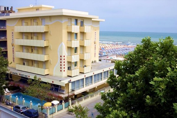 Hotel u pláže s bazénem a výhledem na moře.