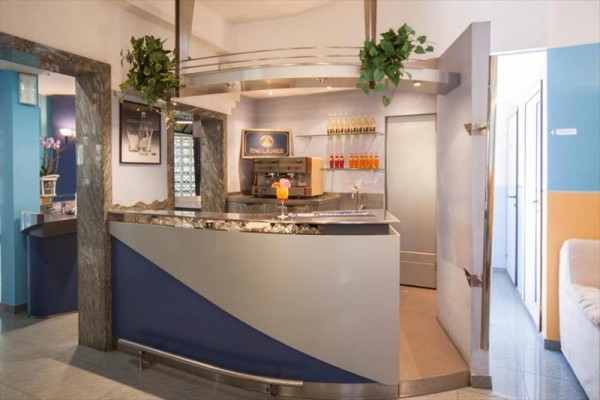 Moderní bar s modrými a šedými tóny a kávovarem.