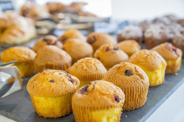 Různé druhy muffinů vystavené na tácku.