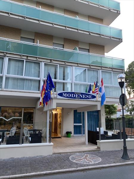 Vchod do hotelu s několika vlajkami nad ním.