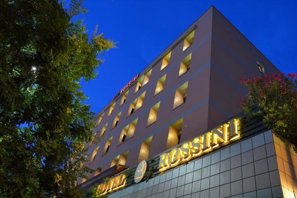 Budova hotelu Rossini osvětlená za soumraku.