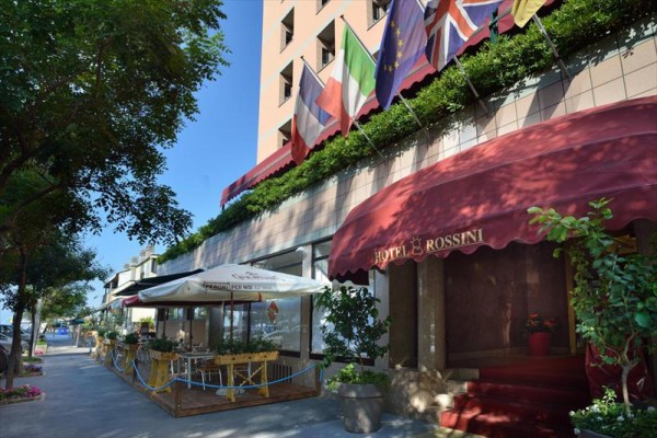 Vstup do hotelu s terasou a vlajkami různých zemí.