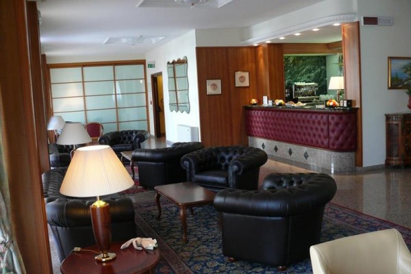 Elegantní hotelová lobby s koženými křesly a recepcí.