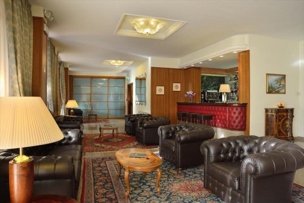 Elegantní hotelová lobby s koženými pohovkami a barem.  
