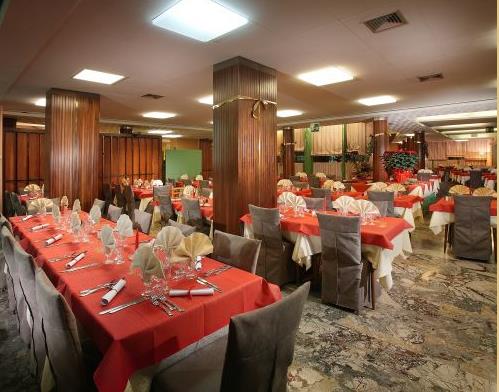 Luxusní restaurace s červenými ubrusy a pečlivě prostřenými stoly.
