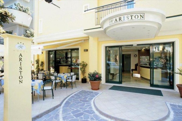 Vstup do hotelu Ariston s terasou a stoly venku.  