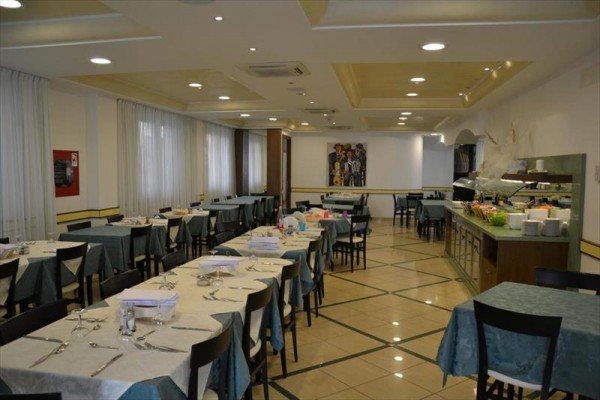 Prostorná restaurace s připravenými stoly a bufetem.