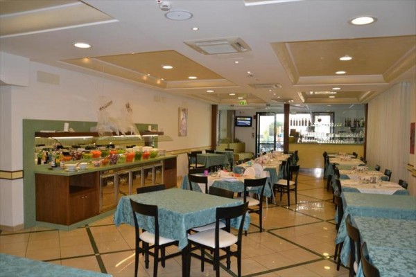 Restaurace s prostřenými stoly a bufetovým pultem.