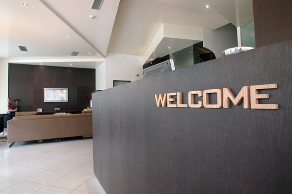 Moderní recepce s nápisem „WELCOME“ na pultu.