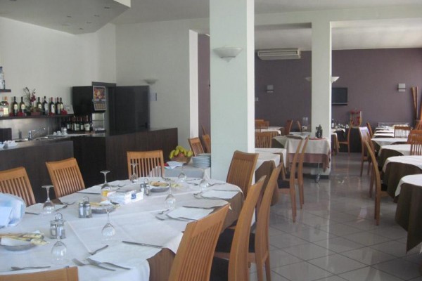 Restaurace s dřevěnými židlemi a prostřenými stoly.