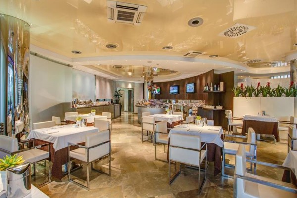 Moderní restaurace s bílými židlemi a dřevěným dekorem.