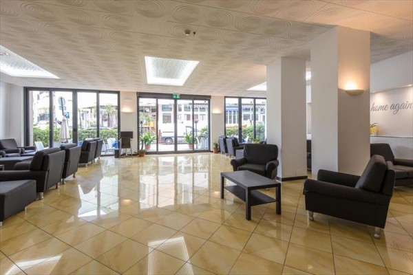 Moderní lobby s černými křesly a velkými okny.