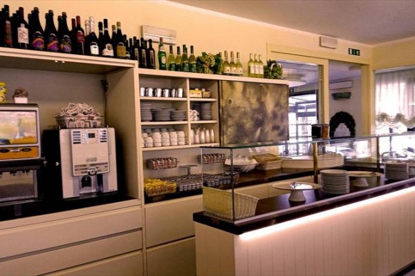 Rautový stůl s kávovarem, nápoji a talíři v hotelové restauraci.