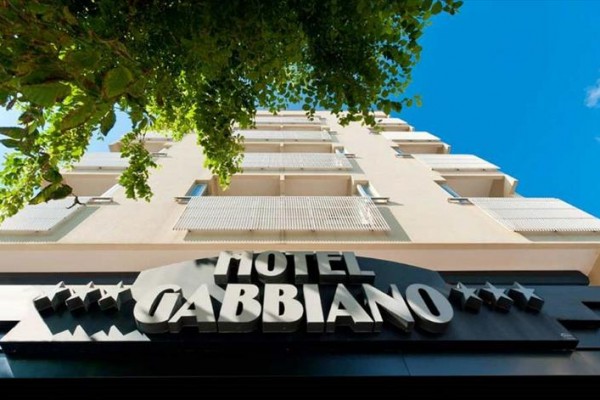 Budova hotelu Gabbiano s nápisem a modrou oblohou.