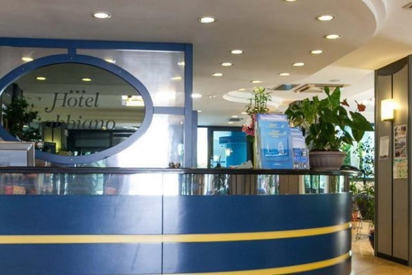 Recepce hotelu s modrým pultem a rostlinami okolo.