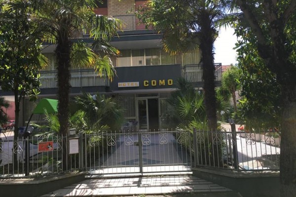 Vstup do hotelu COMO, obklopený palmami.