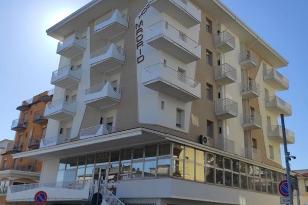 Moderní vícepatrová budova s balkony a nápisem 