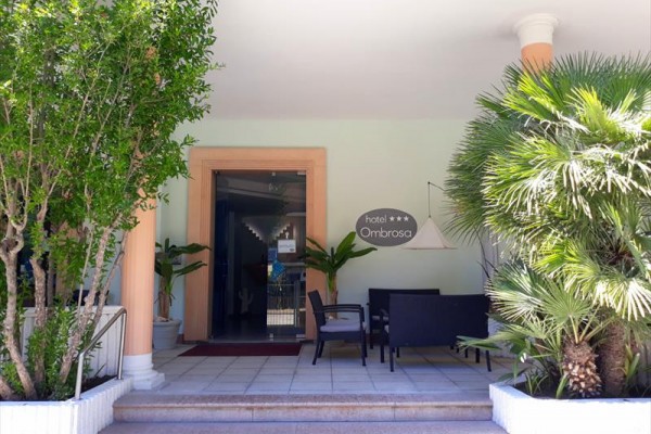 Vchod do hotelu Ombrosa obklopený zelení a venkovním posezením.