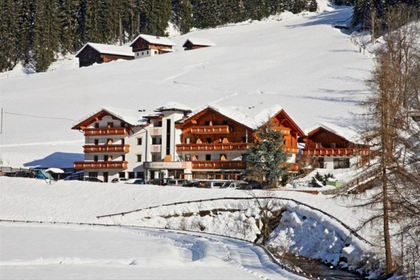 Horský hotel obklopený zasněženou krajinou.