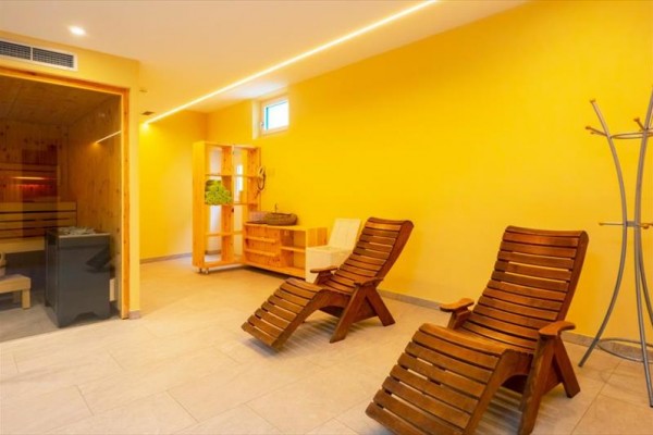 Relaxační místnost se dvěma dřevěnými lehátky a saunou.