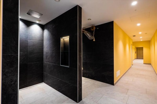 Moderní interiér s černými obklady a žlutými stěnami.