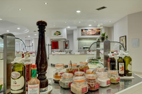 Stůl s výběrem koření a omáček v restauraci s bufetem.