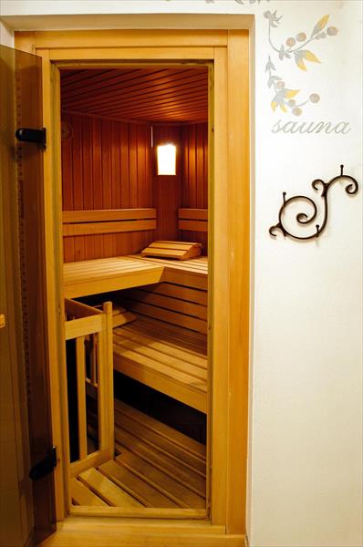 Dřevěná sauna s lavicemi a osvětlením uvnitř.