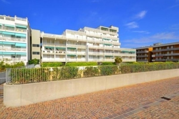 Moderní bytový komplex s balkony na slunečném dni.