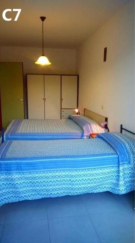 Dva jednolůžkové postele s modrým povlečením v pokoji s šatní skříní.