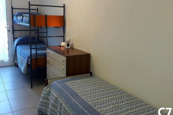 Pokoj se samostatnou postelí, palandou a komodou.